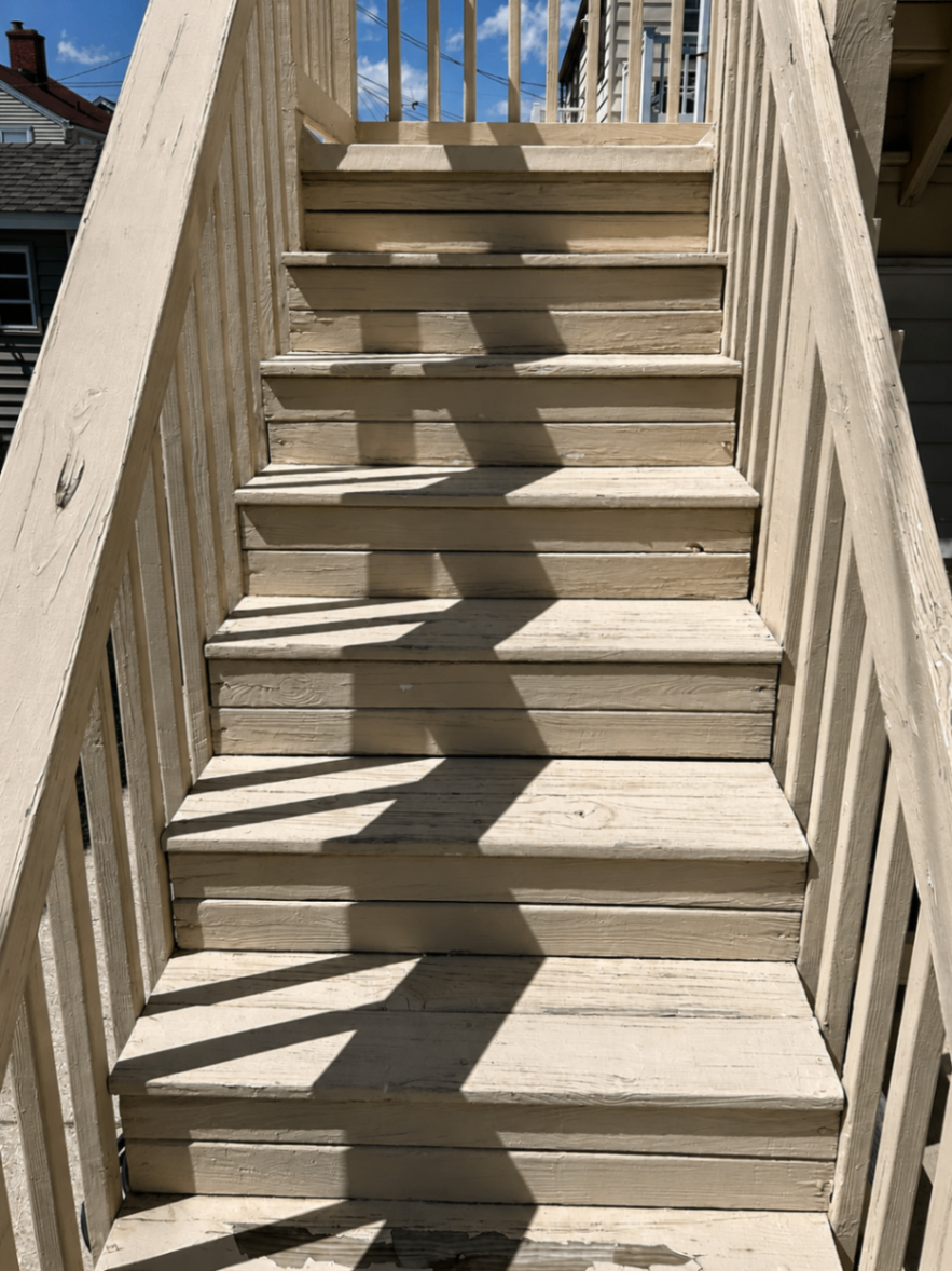 Worn bare wood stair treads before painting