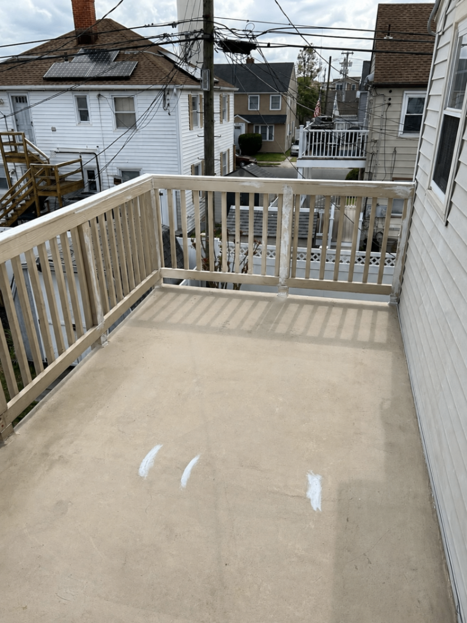 Worn balcony deck and primed railings before coating