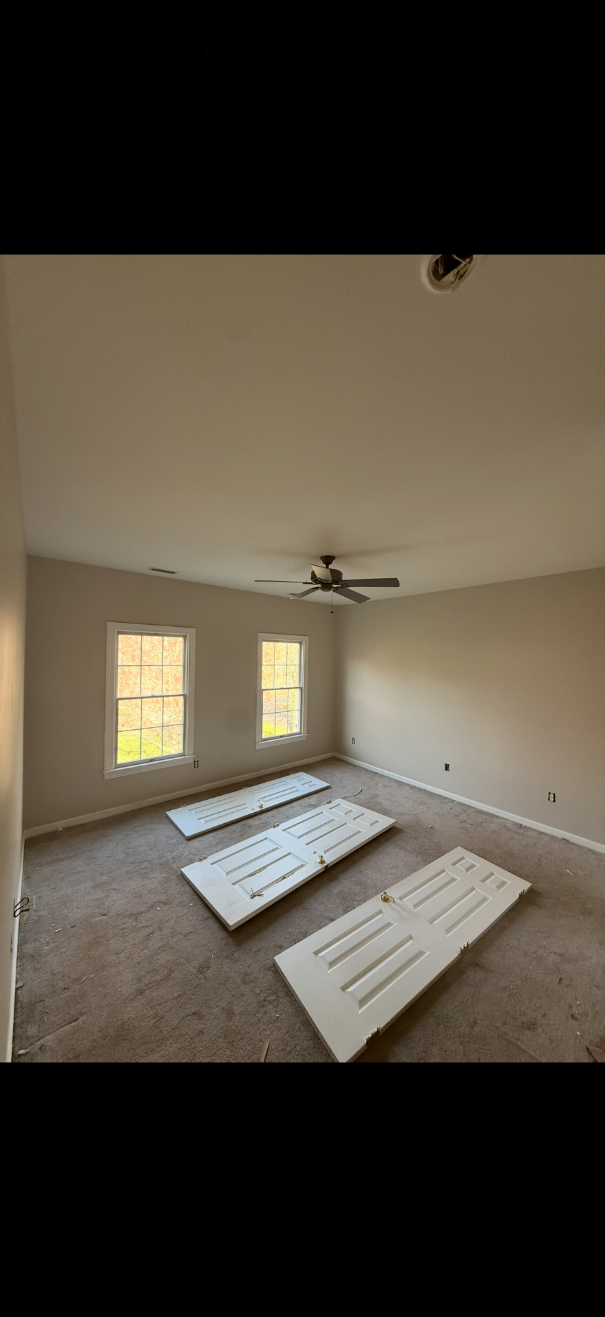 Bedroom with worn carpet and old doors before renovation